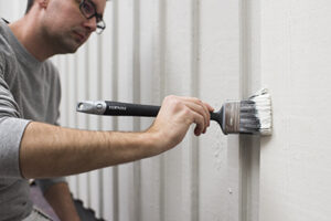 Man målar fasad med platinum lång vinkelpensel