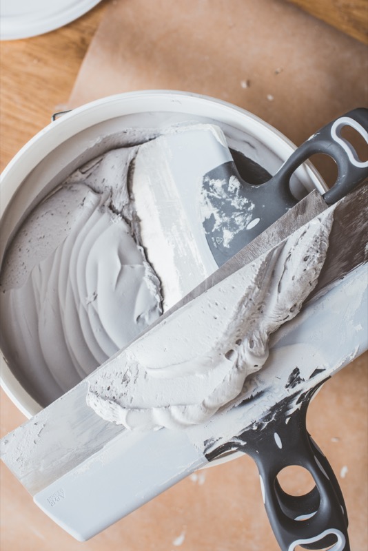 Bredspacklar i en hink med gips